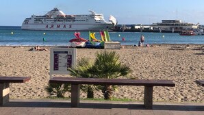 A beach with a cruise ship named 'ARMAS' docked in the background. - Compostela Beach Family Garden Los Cristionas (Arona)