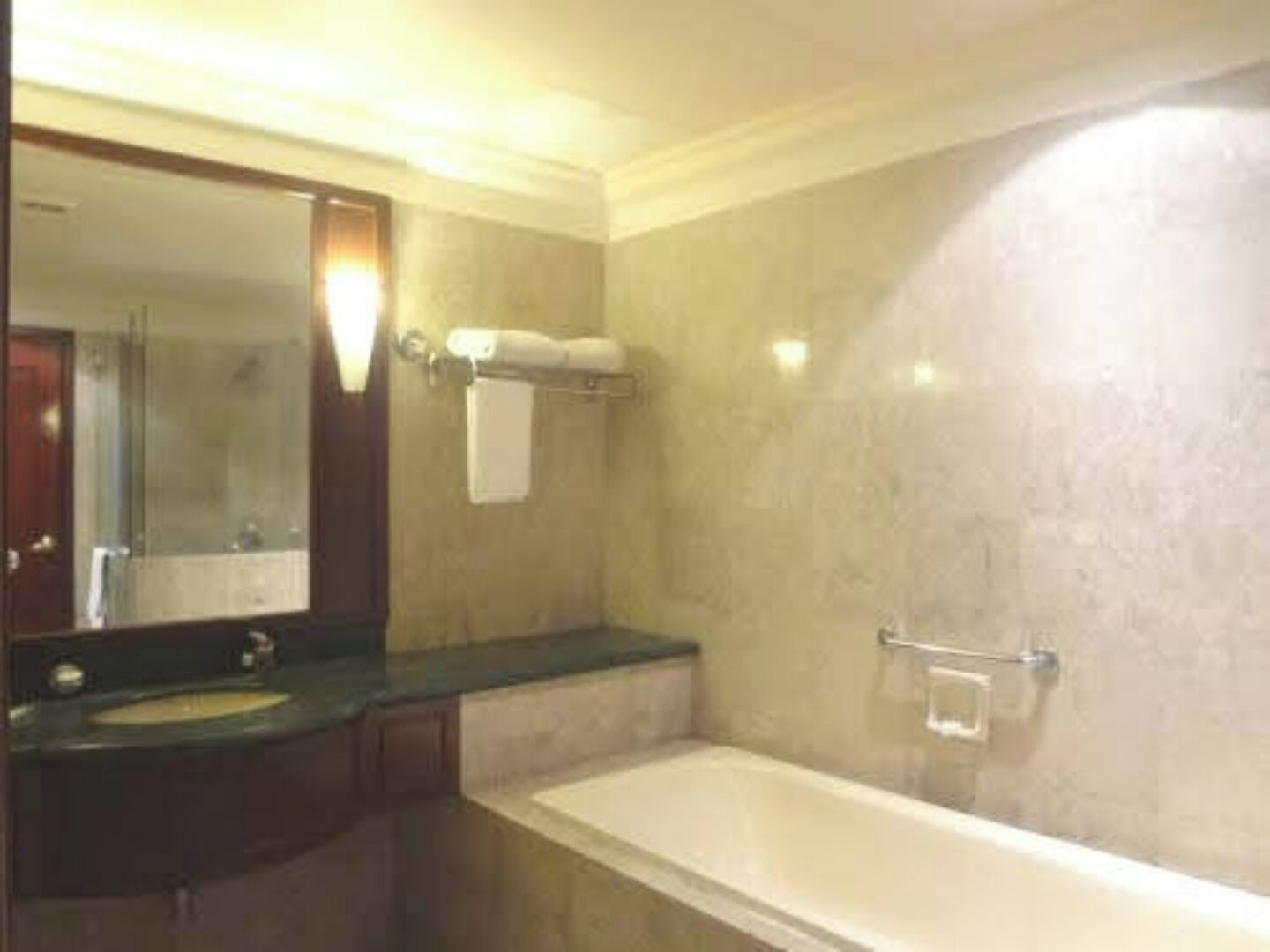 Un baño con bañera, lavamanos y espejo.