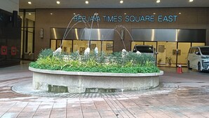 Een waterpartij voor een gebouw, met een bord waarop 'BERJAYA TIMES SQUARE EAST' staat.