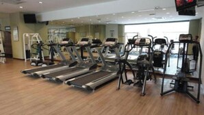 Een sportschool met loopbanden, elliptische trainers en gewichttoestellen.