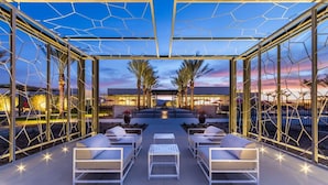 An outdoor lounge area with seating and a view of the sunset. - The Miralon Petite Oasis (Palm Springs)