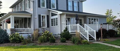 A two-story house with a porch, a covered front porch area, and a white front staircase.