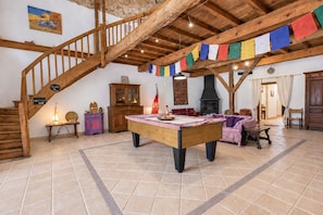 A spacious room with a wooden staircase, a billiards table, and a traditional fireplace. - Soleil de Cocagne – Old Stone & Charm near the Canal du Midi (Lagarde)
