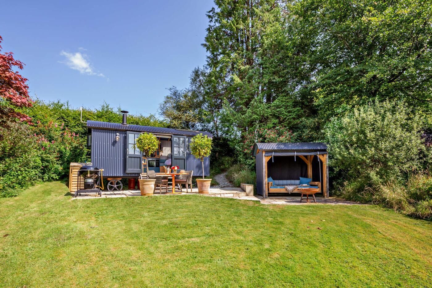 Een compact, modern huis met een klein terras, een eethoek en een gezellige zithoek.