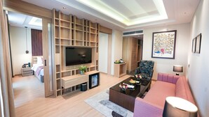 A modern living room with a flat-screen TV, wooden shelving, a sofa, and a coffee table. - NAMAMI BY ZENQ BANKHANDI (Dera Gopipur)