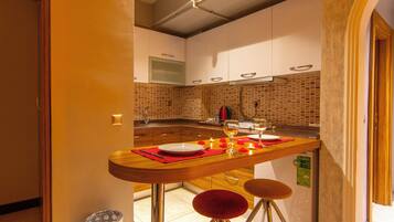 Apartamento standard | Cozinha privada | Frigobar, cooktop, talheres/pratos/utensílios de cozinha