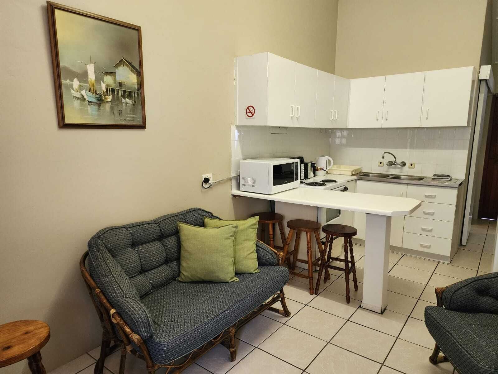 Um espaço compacto com cozinha compacta, sofá e área de refeições.