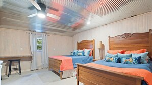 Ein Schlafzimmer mit zwei Holzbetten, einem Schreibtisch und einem Stuhl.