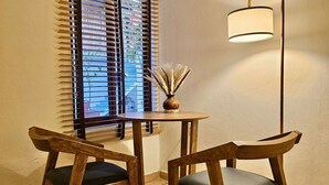 A small dining area with two wooden chairs, a round table, and a floor lamp. - Hidden Gem: Bright and spacious apartment, just steps from Oaxaca’s best spots!  (Oaxaca de Juárez)
