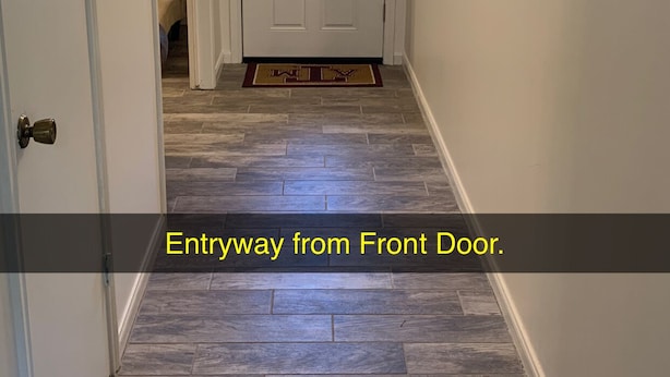 A hallway with a front door, a doormat, and a light fixture on the ceiling. - AggieLand Vacation House!  Charming 3-BR 2-BA only 3 miles from Texas A&M Campus (Bryan)