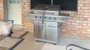 A patio with a stainless steel grill, a door, and a window. - AggieLand Vacation House!  Charming 3-BR 2-BA only 3 miles from Texas A&M Campus (Bryan)