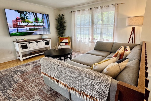 Living area with large sofa and smart TV - connects to kitchen for open concept