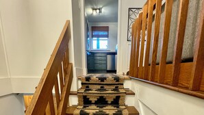Una scala con ringhiera in legno e un tappeto decorato.