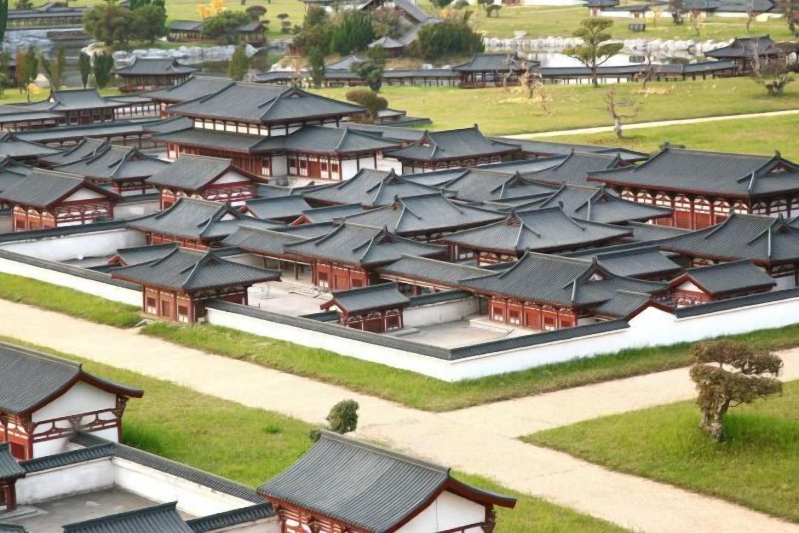 A traditional Japanese-style complex with multiple buildings featuring dark tiled roofs and wooden structures.