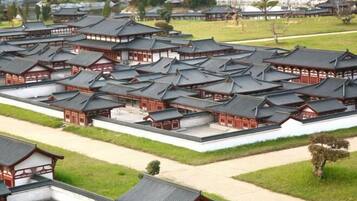 A traditional Japanese-style complex with multiple buildings featuring dark tiled roofs and wooden structures.
