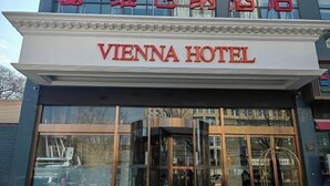 Das Vienna Hotel mit einem markanten Eingang und freiem Blick auf die Umgebung.