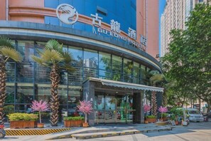 A modern hotel with a curved facade, large glass windows, and a prominent entrance.
