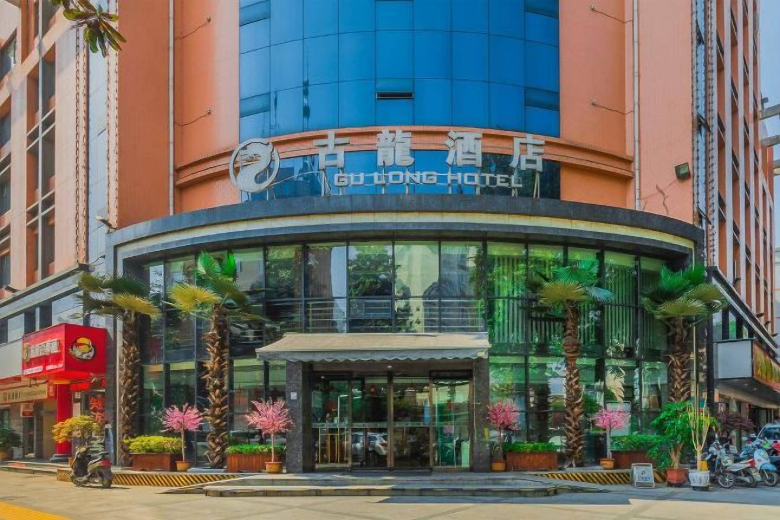 A hotel with a modern glass facade, a curved entrance, and a sign indicating it is the Dong Hotel.