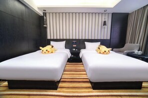 A hotel room with two beds, a large window, a flat-screen TV, and a minibar.