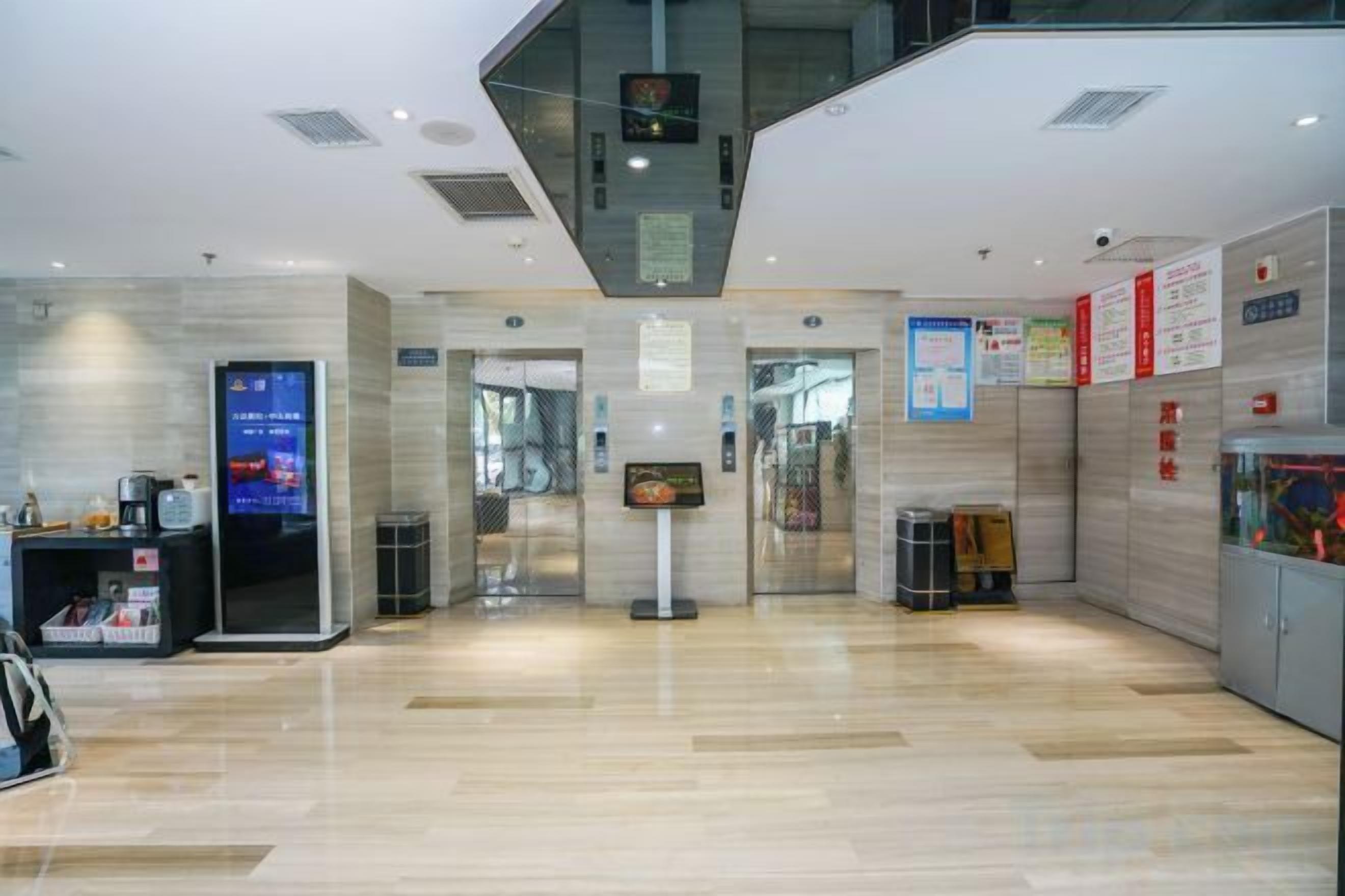 A hotel lobby with a digital information kiosk, a reception desk, and a fish tank.
