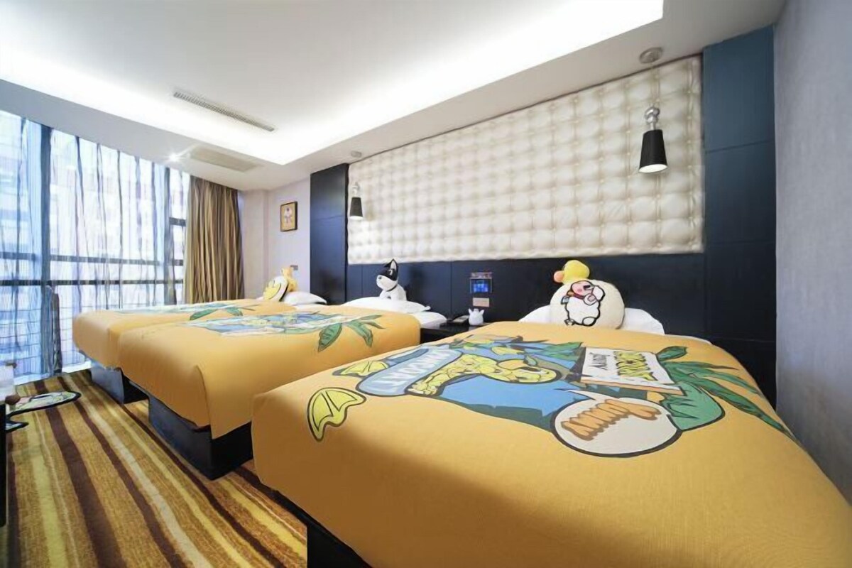 A hotel room with two beds, a large window, a tufted headboard, and a striped carpet.