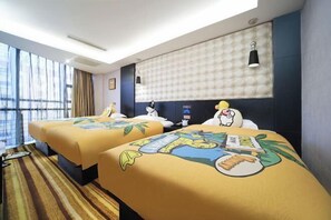A hotel room with two beds, a large window, a tufted headboard, and a striped carpet.