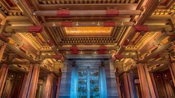 A grand hall with a high ceiling, ornate columns, and a central entrance.