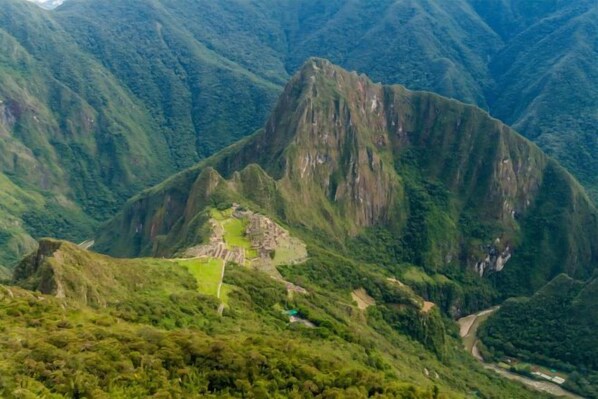 A mountainous landscape with a prominent peak and a small settlement at its base.