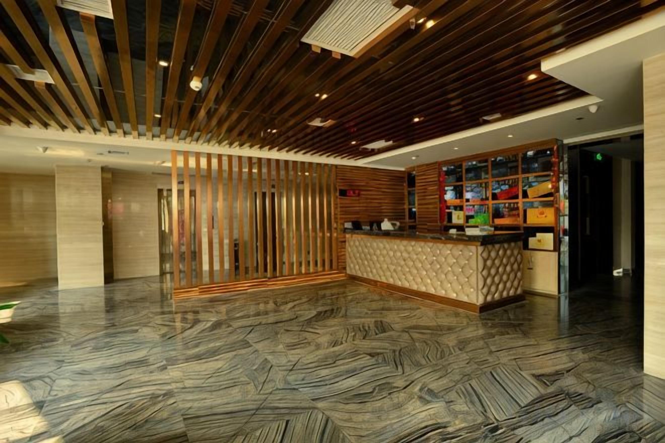 A reception area with a wooden slatted ceiling, a reception desk, and a patterned floor.