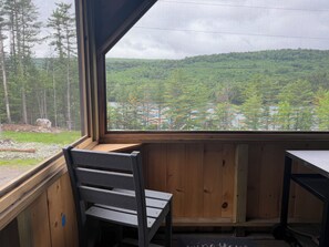 A room with a large window overlooking a forested area.
