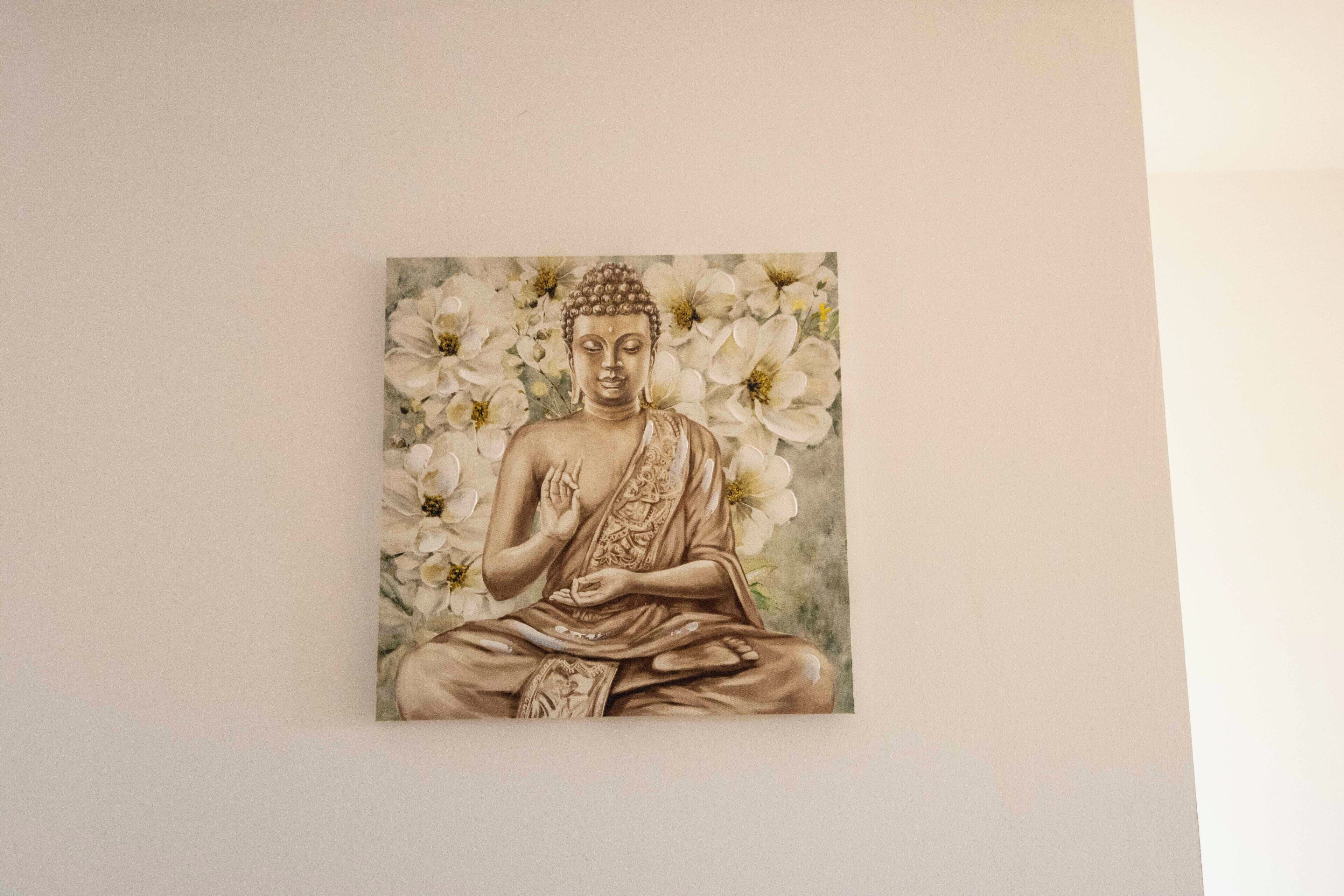 Una pintura d'una figura asseguda envoltada de flors.