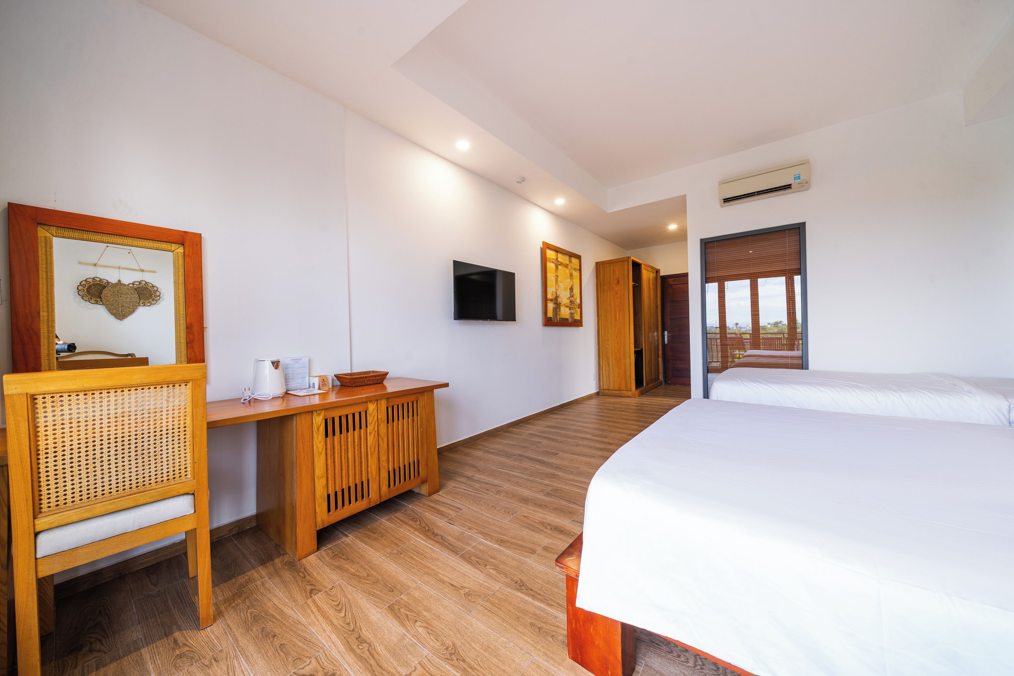 A hotel room with a bed, a desk, a chair, a television, and a window.