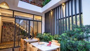 Un comedor moderno con techo alto, una escalera y vistas al exterior.