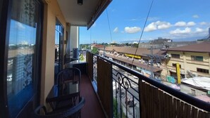 Varanda com vista para a paisagem urbana, uma cadeira e uma mesa.