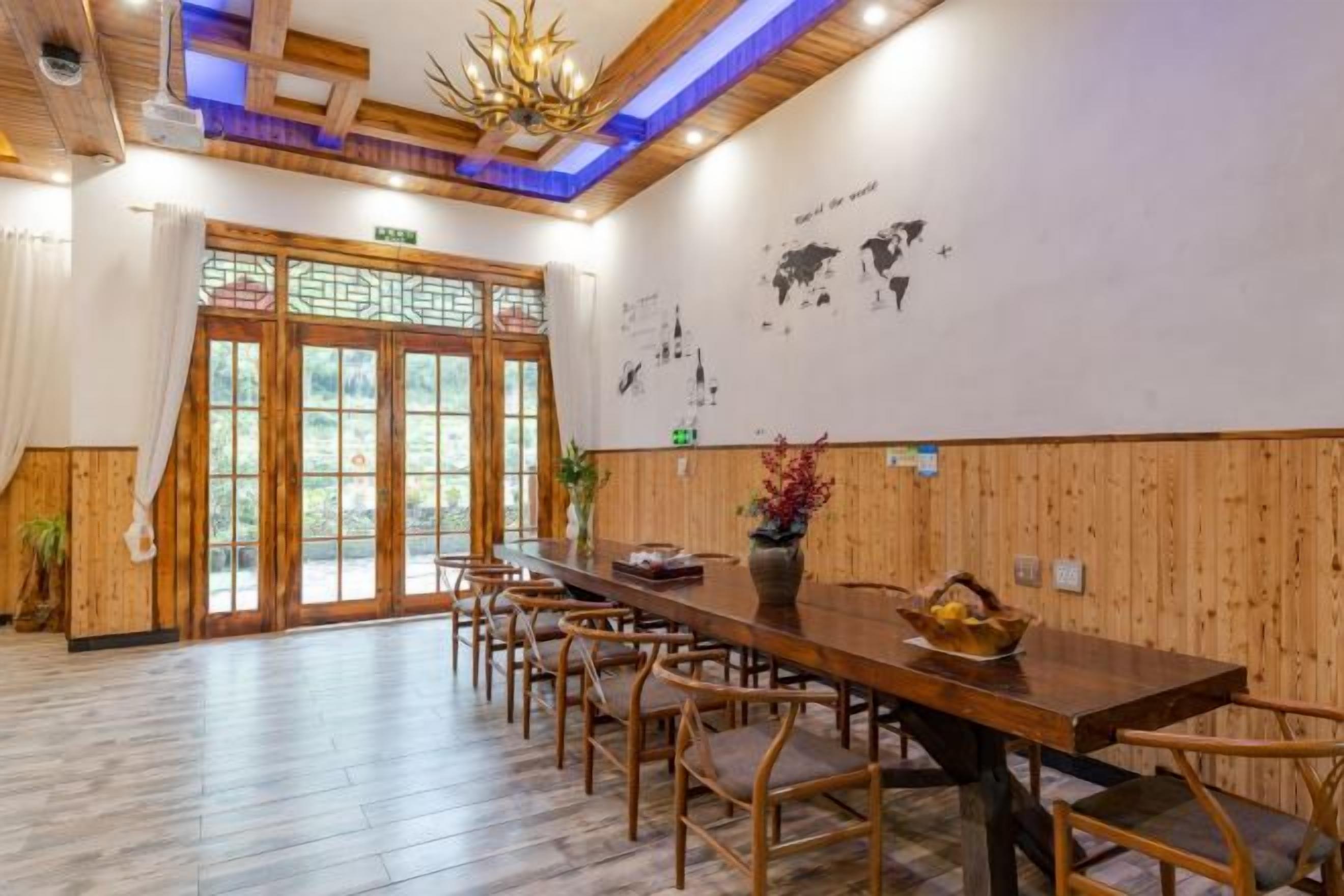 A dining area with a long wooden table, multiple chairs, and a decorative vase.