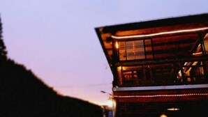 A wooden cabin with a sloped roof and a balcony. - Moganshan Yingju Villa (Deqing)