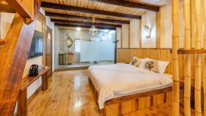 A wooden-floored bedroom with a bed, a bench, and a hanging light fixture. - Moganshan Yingju Villa (Deqing)