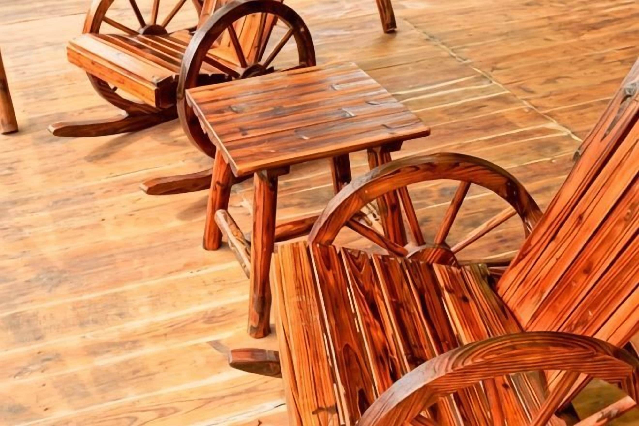 A wooden picnic table and chairs with wheels, set on a wooden floor.