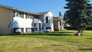 A row of two-story houses with a well-maintained lawn and a large evergreen tree. - Practical-ly home
2 bedroom  quiet and peaceful suite.
tons of natural light
 (Edmonton)