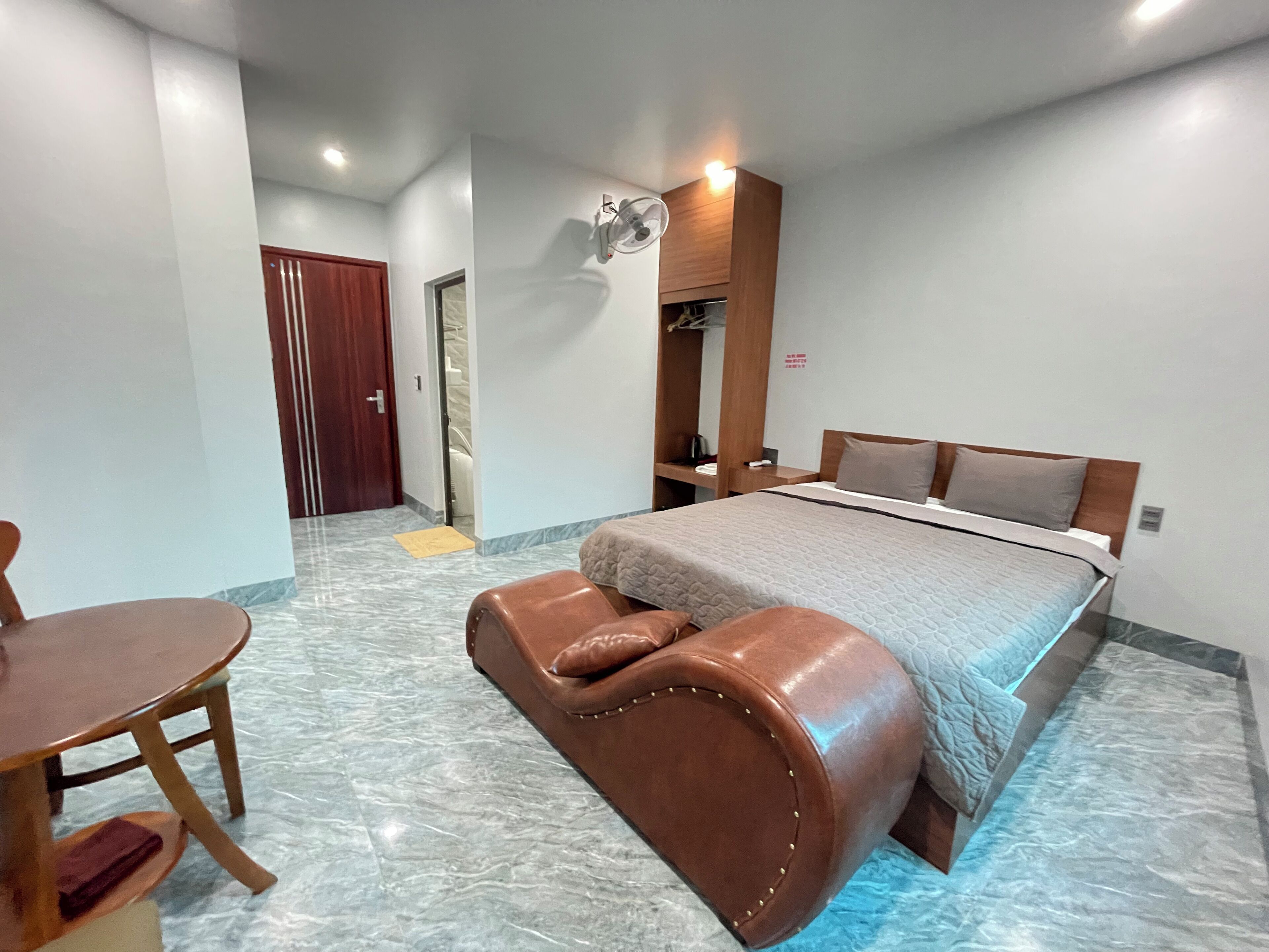 Una habitación de hotel con cama, escritorio, silla y una pequeña mesa.