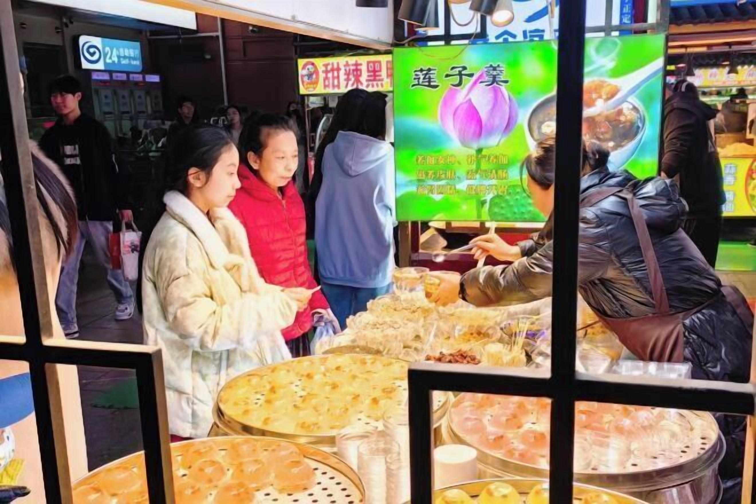 Un stand de restauration de rue où diverses spécialités sont présentées sur des plateaux.