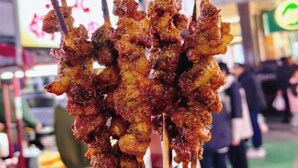 Un puesto de comida callejera con brochetas de carne, probablemente un aperitivo local muy popular.