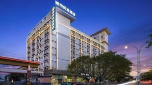 Un hotel de varios pisos con un letrero llamativo en la parte superior.