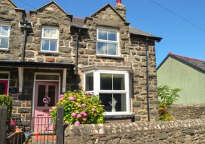 Traditional stone house with a charming bay window and cozy porch area.