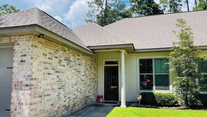 A two-story house with a brick facade and a grey roof.