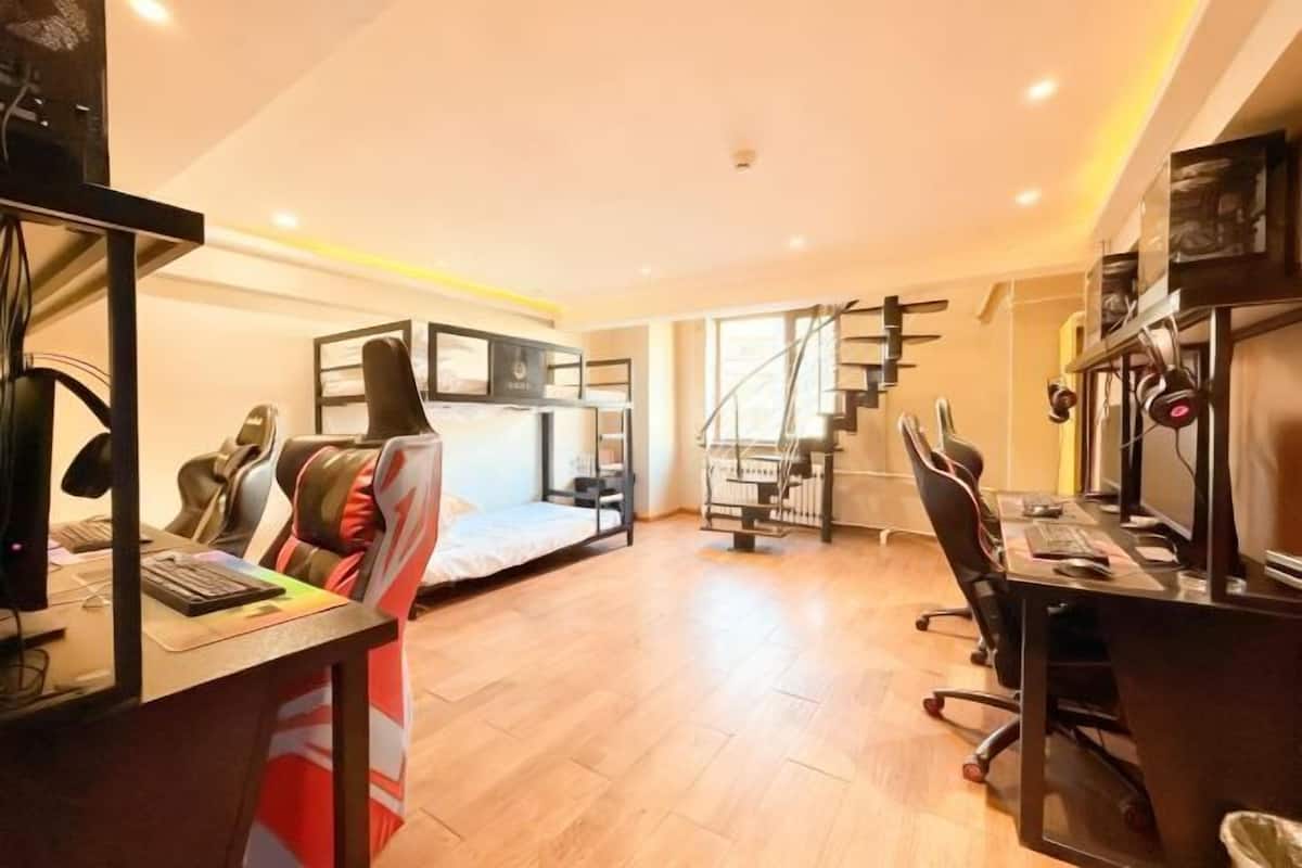 A compact room with a bed, desk, and computer setup.
