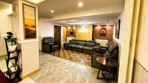 A modern living room with a sofa, a coffee table, and a patterned rug. - Laike Hotel (Harbin Railway Station Museum) (Harbin)
