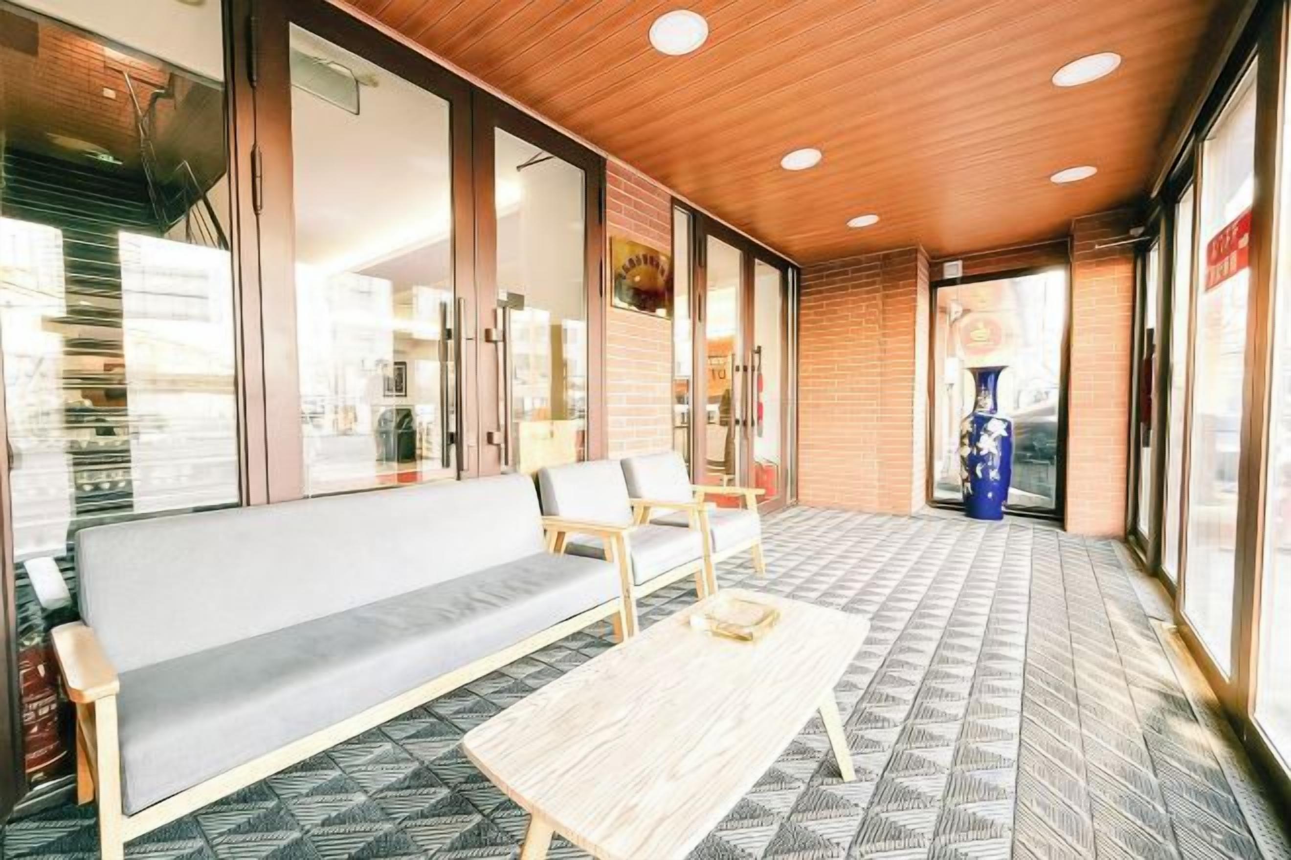 A hotel lobby with a sofa, chairs, a table, and a patterned floor.