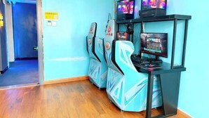 A room with two gaming chairs, a desk with a computer and monitor, and a wall-mounted TV. - Laike Hotel (Harbin Railway Station Museum) (Harbin)
