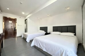 A hotel room with two beds, a wooden door, and a small seating area. - Laike Hotel (Harbin Railway Station Museum) (Harbin)
